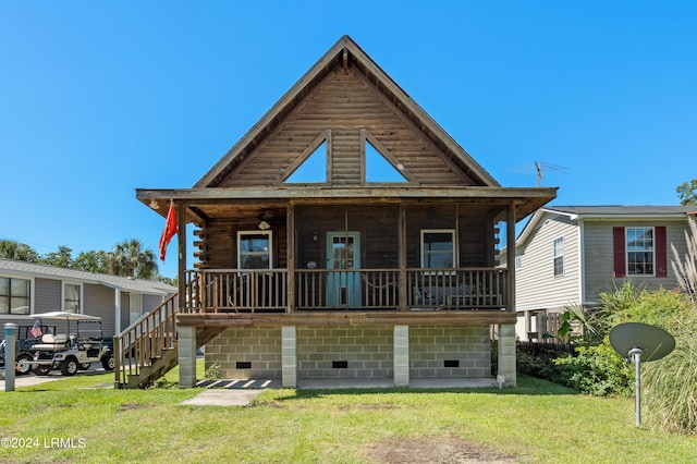 rear view of property featuring a porch and a lawn