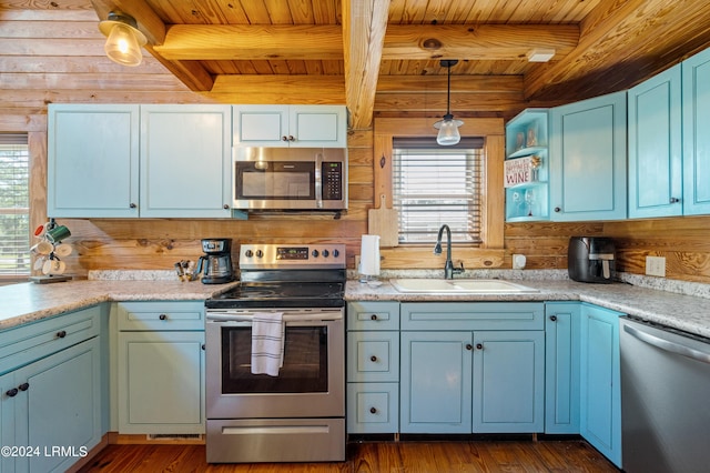 kitchen featuring pendant lighting, beamed ceiling, sink, wood ceiling, and stainless steel appliances