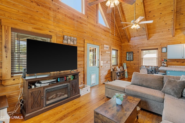 living room featuring wood ceiling, beam ceiling, wooden walls, high vaulted ceiling, and light hardwood / wood-style floors