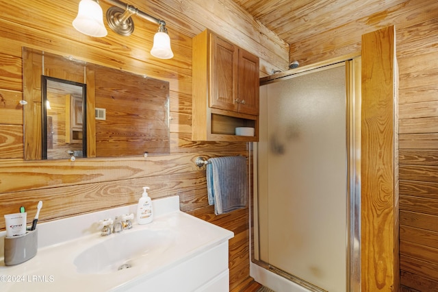 bathroom with vanity, a shower with door, and wood walls