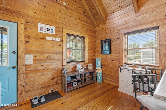 interior space featuring hardwood / wood-style floors, wood walls, beamed ceiling, plenty of natural light, and wooden ceiling