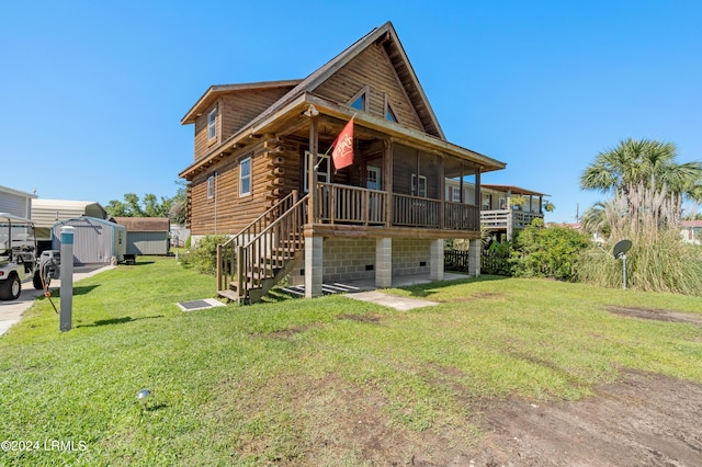 rear view of house with a lawn and a storage unit