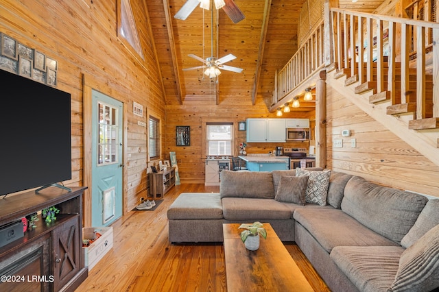 living room featuring wood ceiling, high vaulted ceiling, light wood-type flooring, beamed ceiling, and ceiling fan