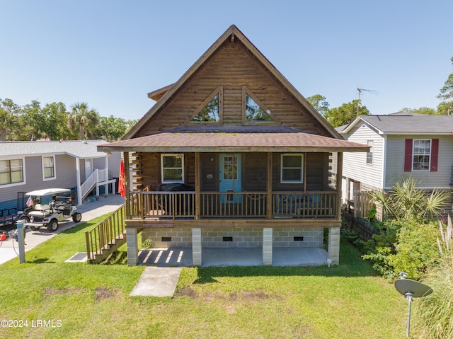 cabin featuring covered porch and a front lawn