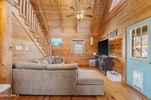 living room featuring wooden ceiling, wooden walls, ceiling fan, beam ceiling, and hardwood / wood-style floors