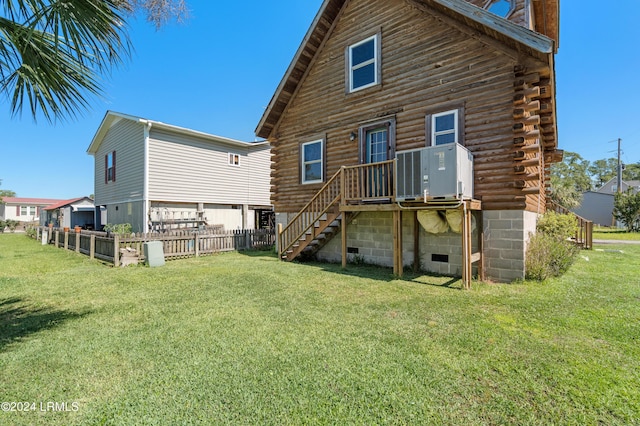 back of property with a lawn and central air condition unit