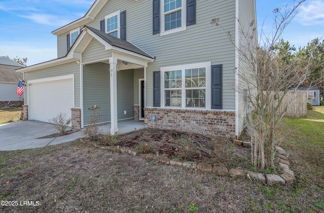 view of front of home featuring driveway, an attached garage, and brick siding