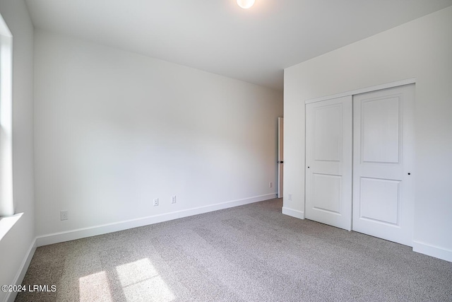 unfurnished bedroom with carpet floors and a closet