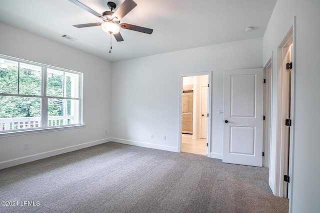 unfurnished bedroom with ensuite bathroom, carpet flooring, and ceiling fan