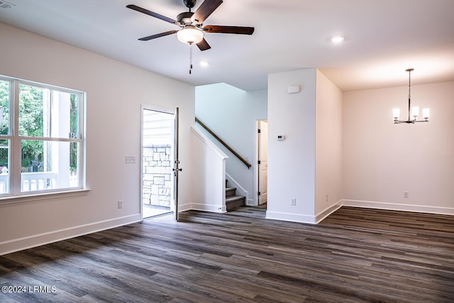 unfurnished room featuring ceiling fan with notable chandelier and dark hardwood / wood-style floors