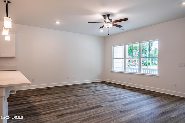 spare room with dark wood-type flooring and ceiling fan