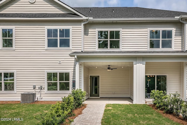 rear view of property featuring ceiling fan, a yard, a patio area, and central air condition unit