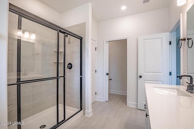 bathroom with tile patterned flooring, vanity, and walk in shower