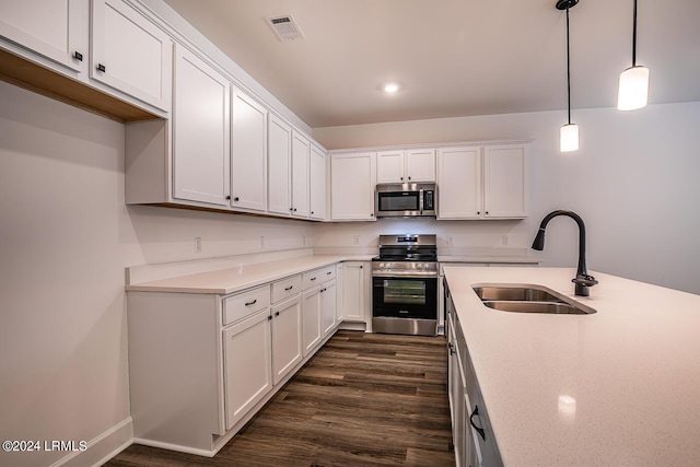 kitchen with dark hardwood / wood-style floors, white cabinetry, sink, hanging light fixtures, and stainless steel appliances