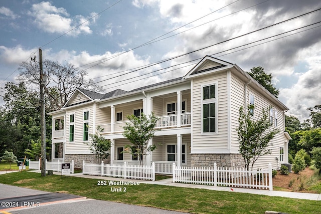 view of front of house featuring a balcony and a front yard