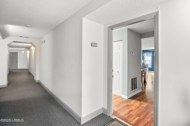 1231 Ladys Island Dr Unit 327, Port Royal, SC 29935 - hall featuring a textured ceiling, carpet flooring, and arched walkways