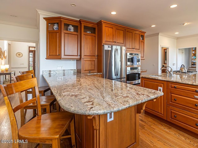 31 Hearthwood Dr, Hilton Head Island, SC 29928 - kitchen featuring a breakfast bar area, a sink, stainless steel appliances, and brown cabinetry