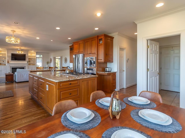 31 Hearthwood Dr, Hilton Head Island, SC 29928 - kitchen with recessed lighting, ornamental molding, stainless steel appliances, a center island with sink, and brown cabinetry
