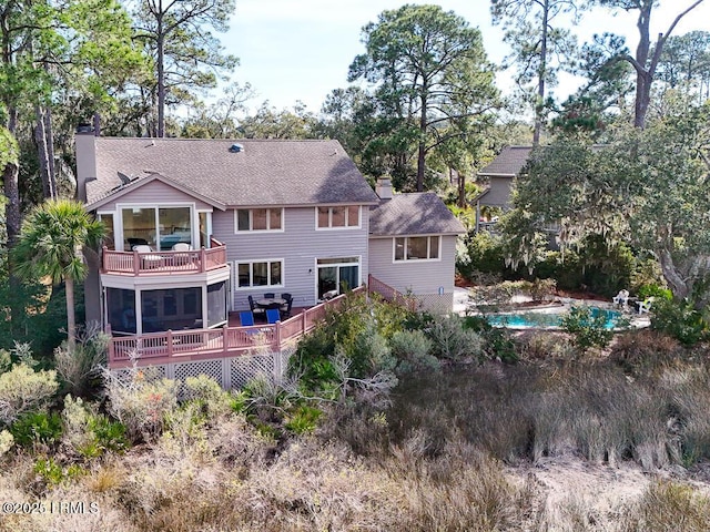 31 Hearthwood Dr, Hilton Head Island, SC 29928 - back of property with a balcony, a wooden deck, an outdoor pool, a chimney, and a shingled roof