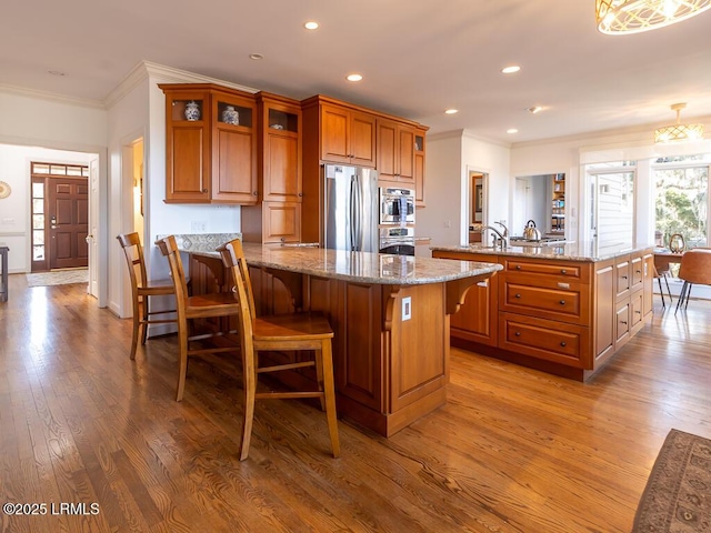 31 Hearthwood Dr, Hilton Head Island, SC 29928 - kitchen featuring ornamental molding, brown cabinetry, a breakfast bar, and appliances with stainless steel finishes