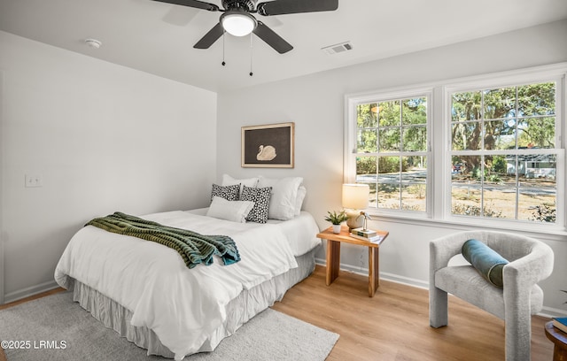 bedroom featuring a ceiling fan, baseboards, visible vents, and light wood finished floors