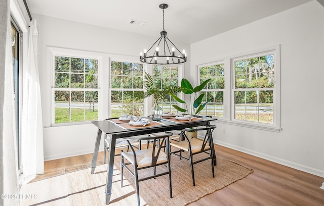 dining room featuring visible vents, baseboards, light wood-style flooring, and an inviting chandelier