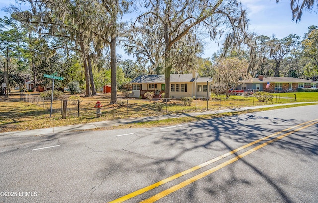 single story home featuring a fenced front yard and a chimney