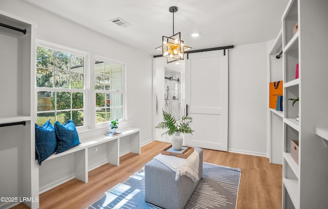 spacious closet featuring light wood-style flooring, visible vents, and a barn door