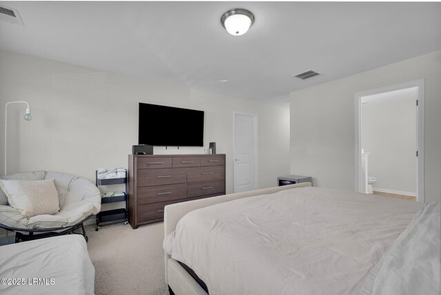 bedroom featuring light colored carpet and ensuite bathroom