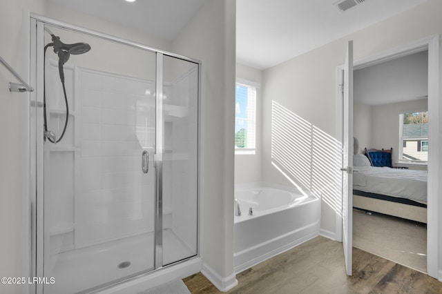 bathroom featuring wood-type flooring and separate shower and tub