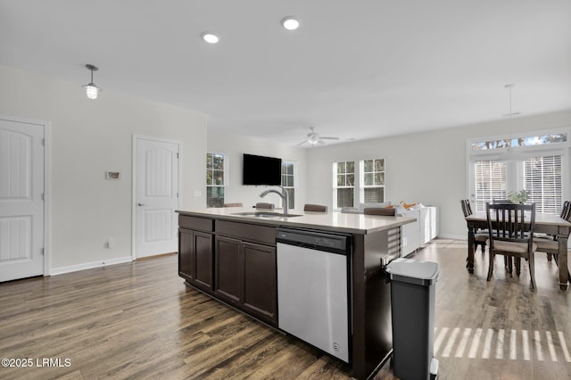 kitchen with hanging light fixtures, sink, stainless steel dishwasher, and an island with sink