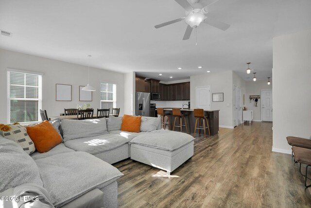 living room featuring dark hardwood / wood-style flooring, sink, and ceiling fan