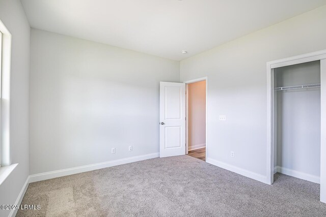 unfurnished bedroom featuring carpet flooring and a closet