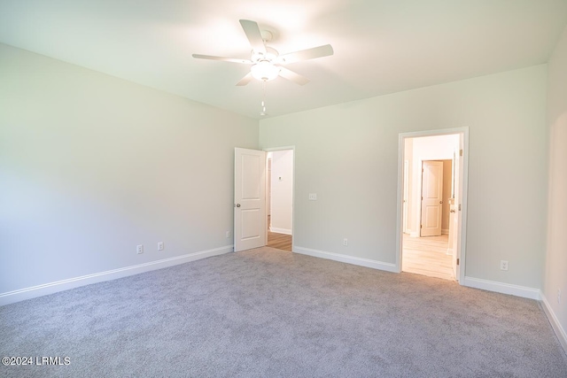 unfurnished bedroom with light colored carpet and ceiling fan