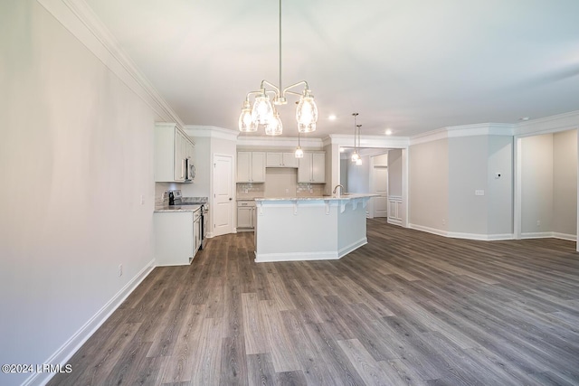 kitchen with pendant lighting, a kitchen island with sink, white cabinetry, stainless steel appliances, and ornamental molding