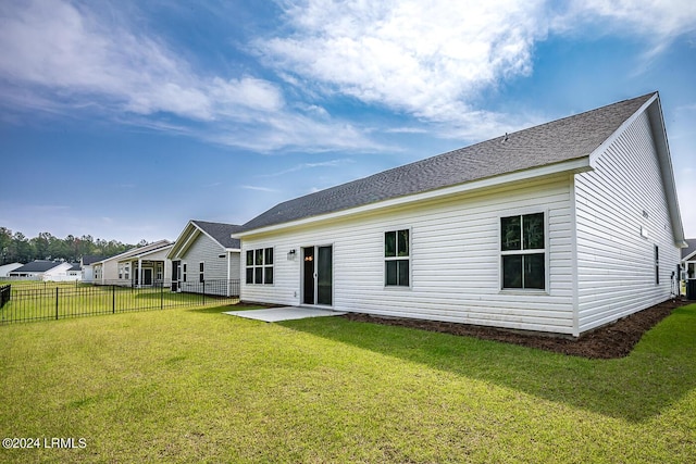 rear view of house featuring a lawn and a patio