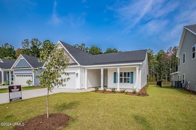 view of front of house with cooling unit, a garage, a front yard, and a porch