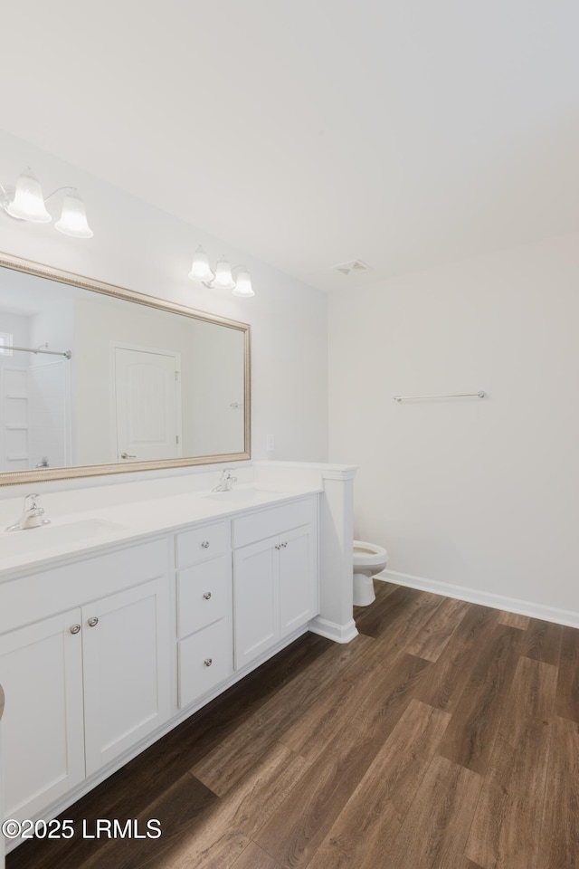 61 Conifer St, Hardeeville, SC 29927 - bathroom featuring double vanity, wood finished floors, toilet, baseboards, and a shower