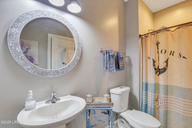 bathroom with walk in shower, sink, and toilet