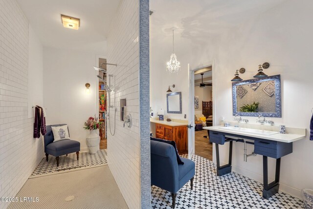 bathroom with vanity and ceiling fan with notable chandelier