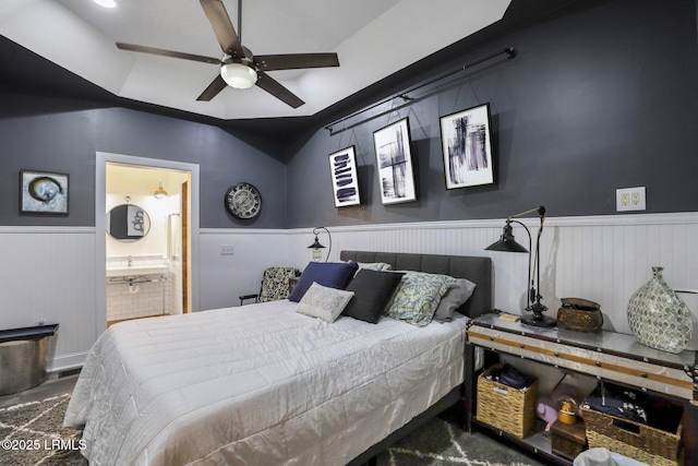 bedroom with ceiling fan, lofted ceiling, and connected bathroom