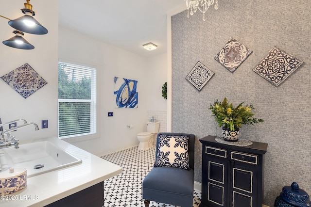 bathroom with tile walls, sink, and toilet