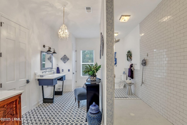 bathroom featuring tiled shower and a notable chandelier