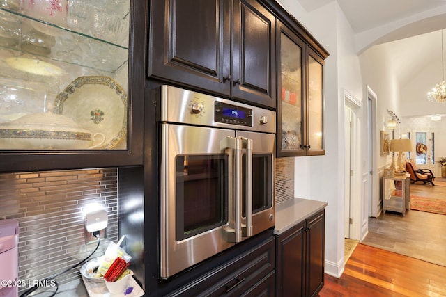 kitchen featuring dark hardwood / wood-style floors, stainless steel oven, and dark brown cabinetry