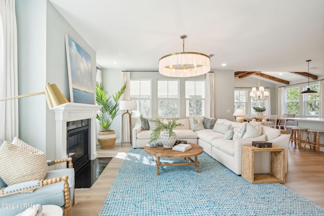 living room featuring beamed ceiling, a notable chandelier, and light hardwood / wood-style floors