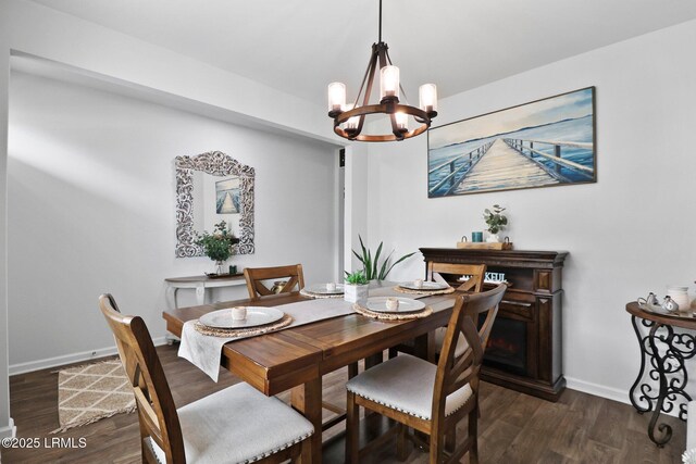 dining space with a chandelier, baseboards, and wood finished floors