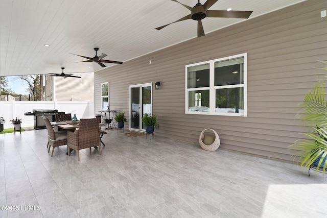 view of patio with outdoor dining area, a grill, fence, and ceiling fan