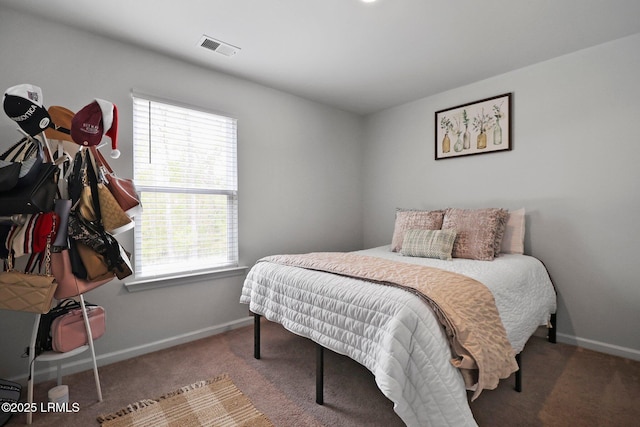 carpeted bedroom with visible vents, multiple windows, and baseboards