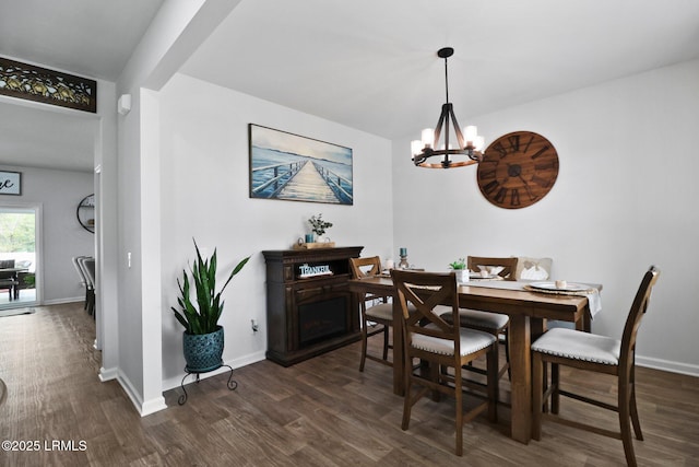 dining area featuring a chandelier, baseboards, and dark wood-style floors