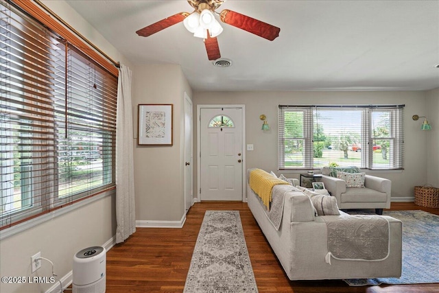 living room with dark wood finished floors, ceiling fan, and baseboards